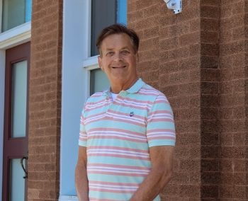 Rob Kreibich smiling in front of a brick building